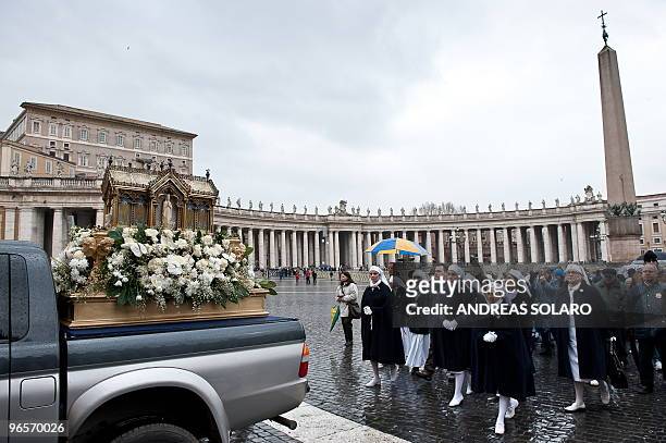 Faithful follow the reliquary of St Bernadette Soubirous on St Peter's square at The Vatican during a procession ending at St Peter's basilica prior...