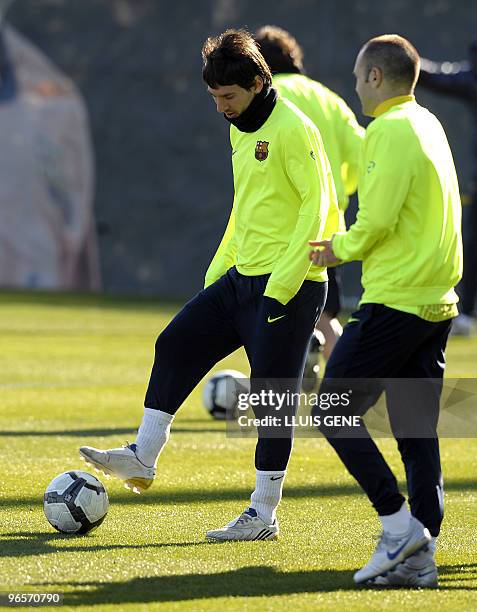Barcelona's Argentinian forward Lionel Messi controls a ball next to Barcelona's midfielder Andres Iniesta during a training session at Ciutat...