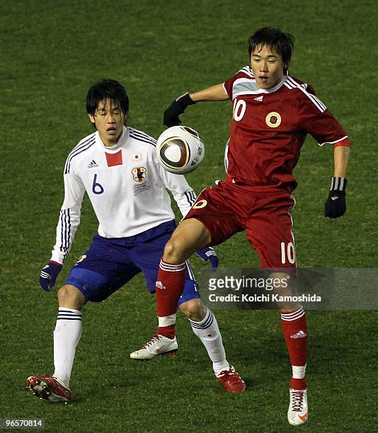 Atsuto Uchida of Japan and Yiu Chung Au Yeung of Hong Kong compete for the ball during the East Asian Football Championship 2010 match between Japan...