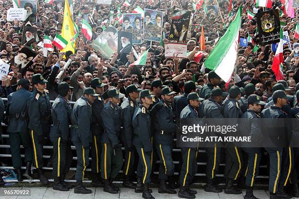 Iranian security forces stand guard as tens of thousands of Iranians gather in Azadi Square in southwestern Tehran to listen to a speech by President...