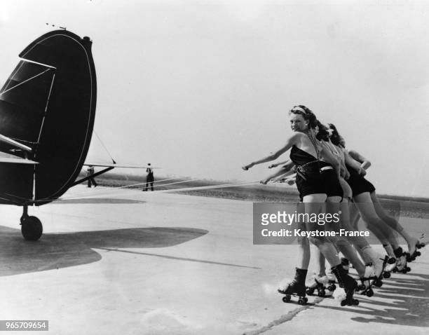 Nouveau sport lancé en Californie, l'aéroplaning, o�ù ces jeunes filles, munies de patins à roulettes, se font remorquer par un avion qui les entraîne...