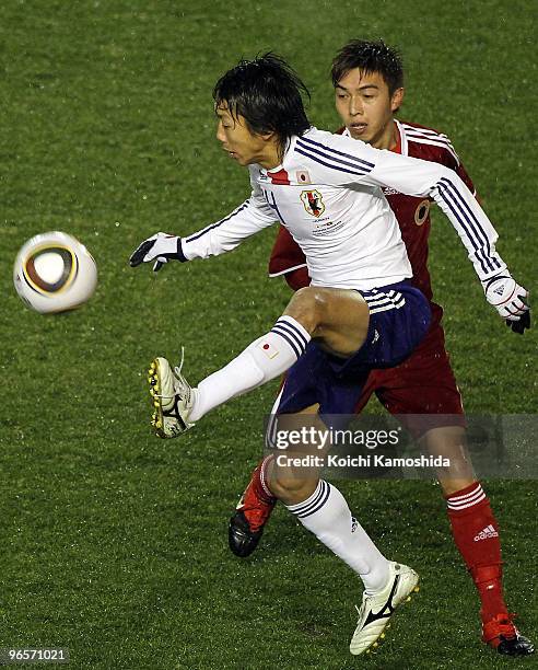 Kengo Nakamura of Japan controls the ball with Chin Hung Wong of Hong Kong during the East Asian Football Championship 2010 match between Japan and...