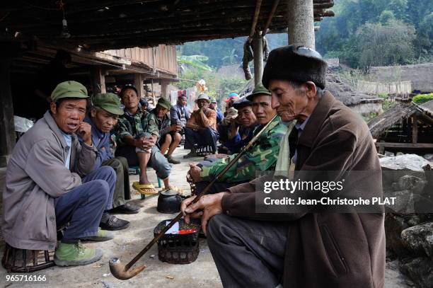 Homme fumant lors dune ceremonie funeraire d'une personne decede il y a plus de 40 ans au village de Weng Ding, le 17 decembre 2013, Yunnan, Chine.