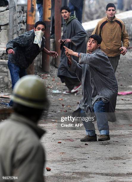 Kashmiri demonstrators throw stones during clashes with Indian police in Srinagar on February 11, 2010. A security lockdown and a general strike...