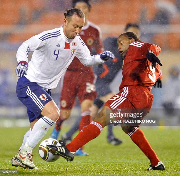 Japan's defender Marcus Tulio Tanaka and Hong Kong's defender Gerard Ambassa Guy fight for the ball during the four-team East Asian football...