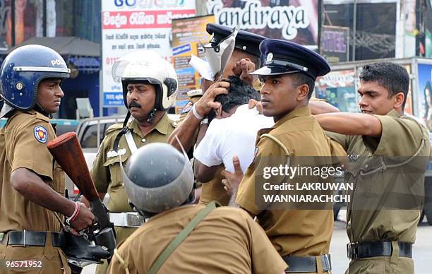 Sri Lankan policemen subdue a demonstrator in the eastern Colombo suburb of Maharagama on February 11, 2010. Sri Lankan police used batons and tear...