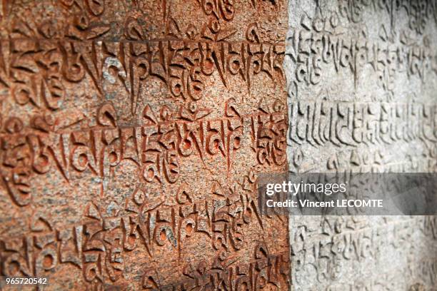 Pierres gravées avec des formules bouddhistes en caractères tibétains le long d'un sentier de la région du Tamang au Népal, le 21 avril 2012 - Ces...