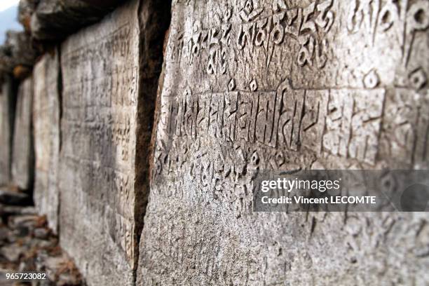 Pierres gravées avec des formules bouddhistes en caractères tibétains le long d'un sentier de la région du Tamang au Népal, le 21 avril 2012 - Ces...