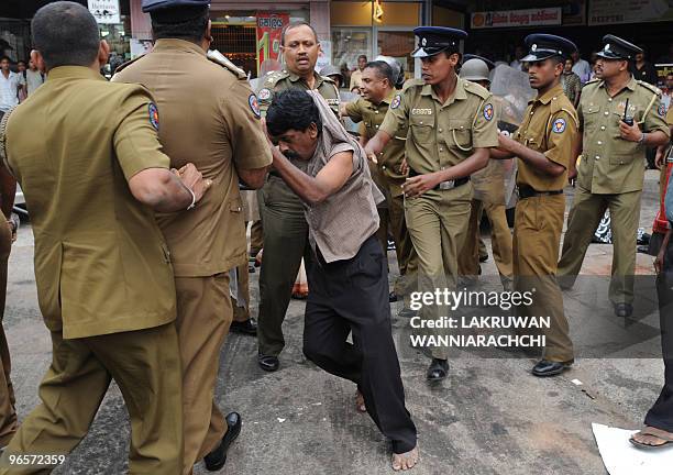 Sri Lankan policemen subdue a demonstrator in the eastern Colombo suburb of Maharagama on February 11, 2010. Sri Lankan police used batons and tear...