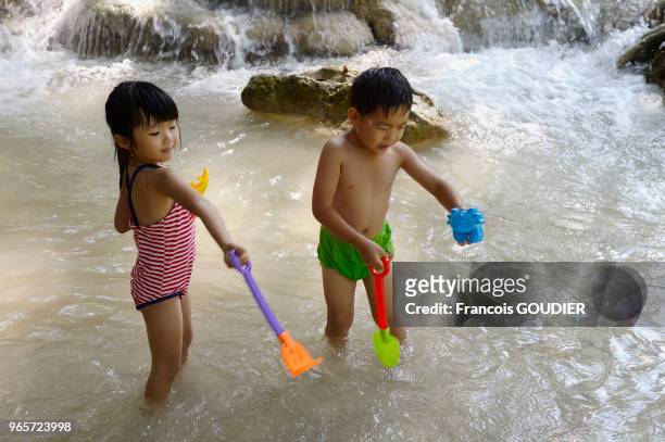 Enfants jouant près de la chute d'eau de Kuang si Waterfall, 24 octobre 2015, Laos.