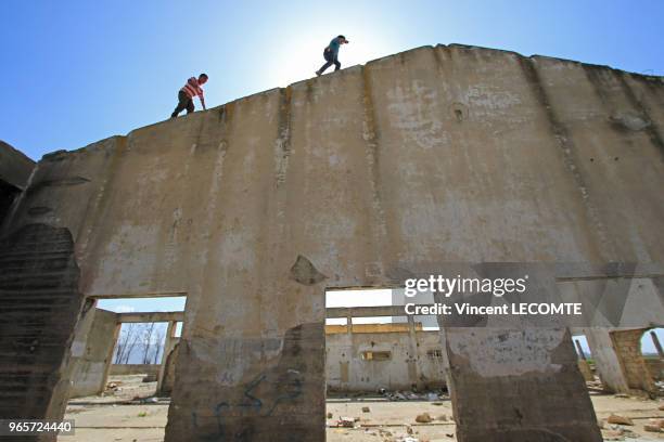 Enfants syriens errant dans un bâtiment en ruines dans lequel ils travaillent à récupérer des matériaux de construction pour les revendre - Ils ont...