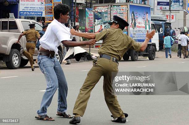 Sri Lankan policeman tussles with a demonstrator in the eastern Colombo suburb of Maharagama on February 11, 2010. Sri Lankan police used batons and...