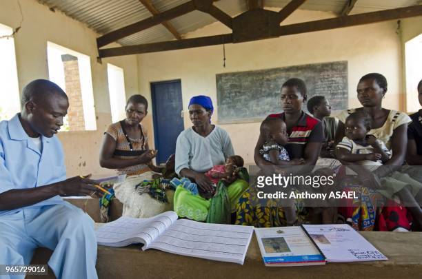 Malawi, Northern Region, Rumphi, Health Surveillance Assistant Bruno Banda checks the condition of children at Chozoli Village Clinic in Rumphi...