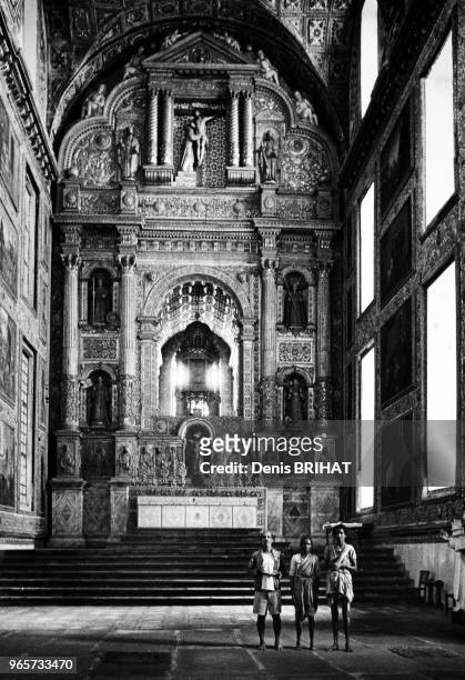Trois personnes dans le choeur de la cathédrale de Goa, en 1955, Inde.