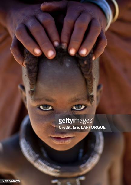 Elola village Like himba ones, pre pubescent muhimba girls wear 2 plaits in front of their faces.