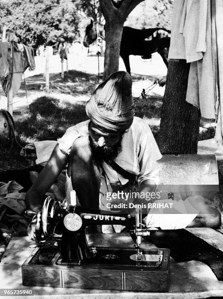 Homme utilisant une machine à coudre Inde.
