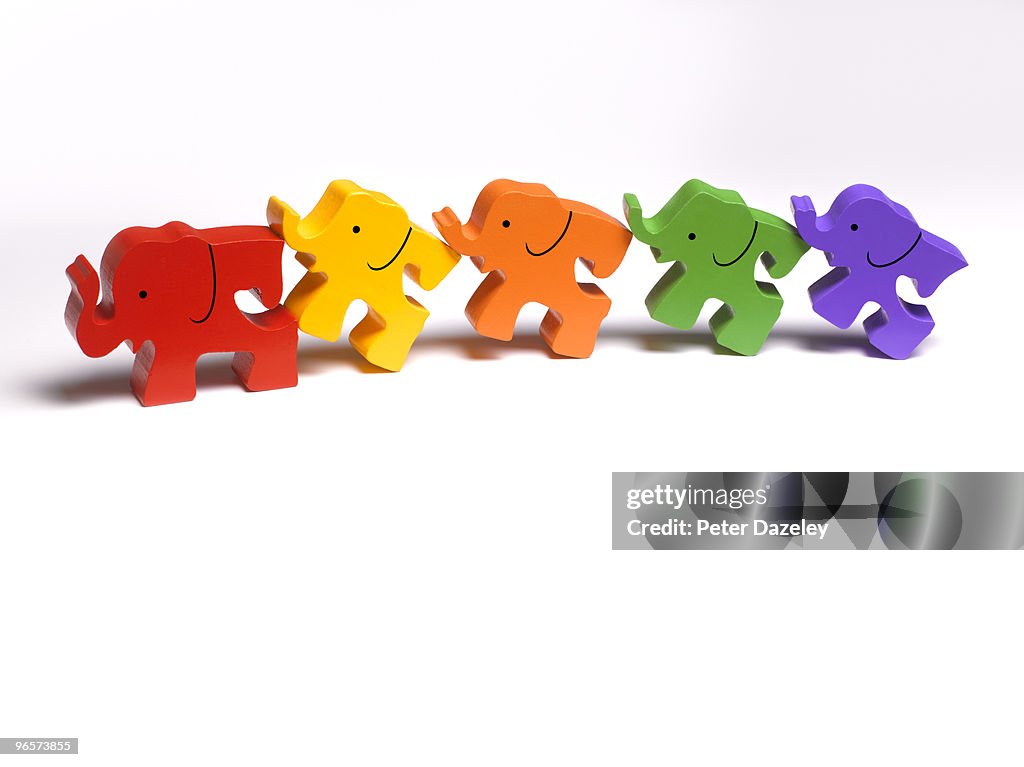 Family of wooden toy elephants in a line