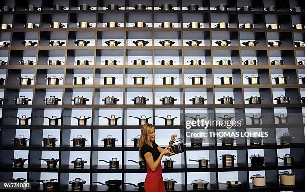 Model presents pots at the stand of company Holland Cookware during the consumer goods trade fair "Ambiente" in Frankfurt/Main, western Germany on...