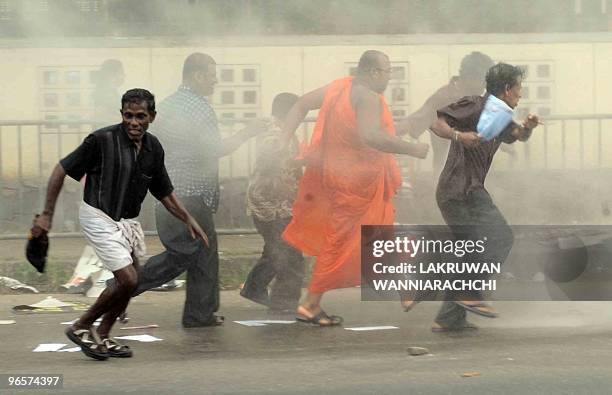 Sri Lankan demonstrators run through a cloud of teargas fired by authorities during a protest in the eastern Colombo suburb of Maharagama on February...
