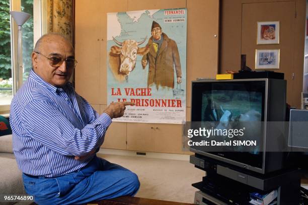 French Movie Director Henri Verneuil With Poster Of His Movie La Vache Et Le Prisonnier Now Colorized, June 14, 1990.