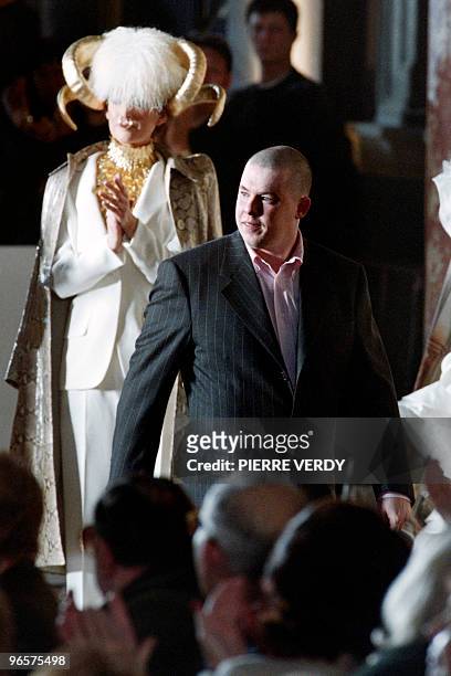 Givenchy's British designer Alexander McQueen is applauded at the end of the presentation of his spring/summer Haute Couture collections on January...