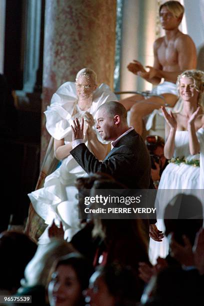 Givenchy's British designer Alexander McQueen is applauded at the end of the presentation of his spring/summer Haute Couture collections on January...