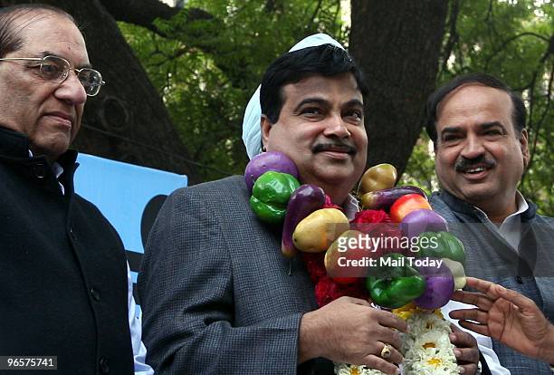 President Nitin Gadkari wears a garland of vegetables with party leaders Vijay Kumar Malhotra and Ananth kumar during a protest against price rise in...
