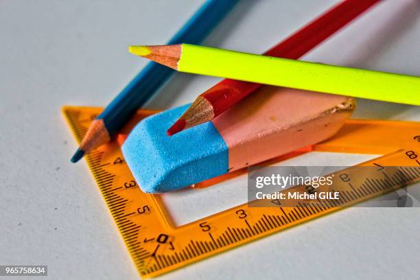 Gomme bleue et rose, trois crayons de couleurs et équerre jaune, France.