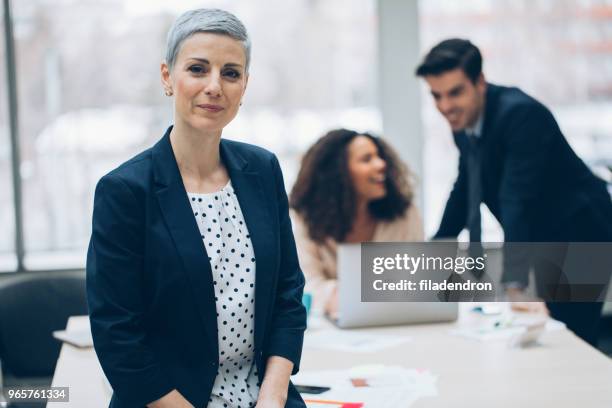 portrait of a middle aged businesswoman - staff wellbeing stock pictures, royalty-free photos & images