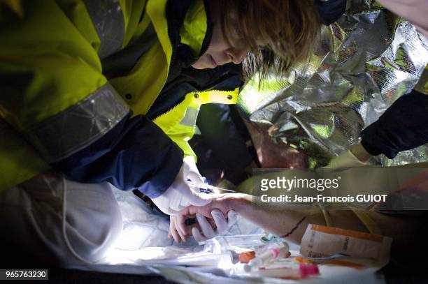 Pose d'une perfusion durant une intervention des services d'urgence aupres d'une victime suite a un accident de la route, le 15 janvier 2011, France.