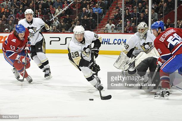 Kris Letang of Pittsburgh Penguins skate with the puck in front of Ryan White of Montreal Canadiens during the NHL game on February 6, 2010 at the...