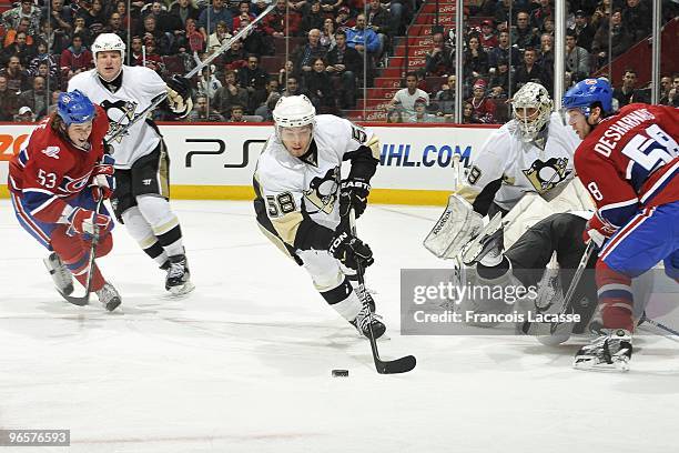 Kris Letang of Pittsburgh Penguins skate with the puck in front of Ryan White of Montreal Canadiens during the NHL game on February 6, 2010 at the...