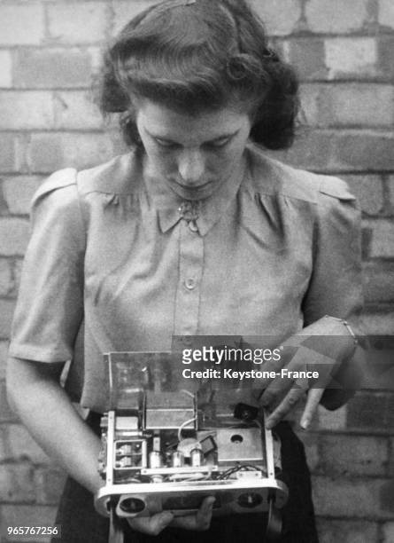 Une femme présente une radio portative qui sera bientôt en vente au public pour £18 le 21 août 1946.