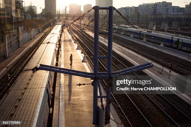 Femme sur les quais de la gare Montparnasse en contre-jour, Paris.