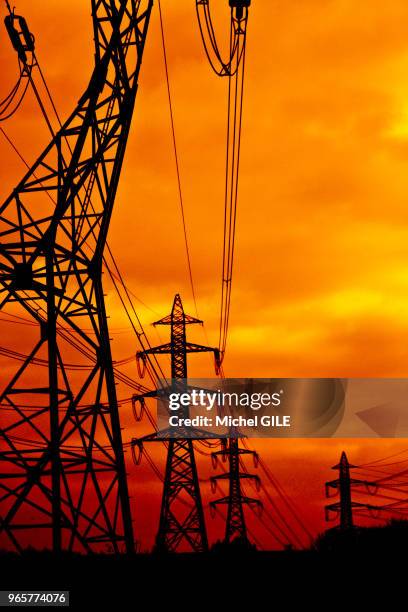 Pylones haute tension au coucher du soleil.