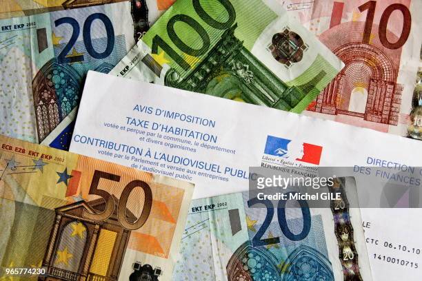 Divers billets de banque en euros et avis d'imposition de la taxe d'habitation.
