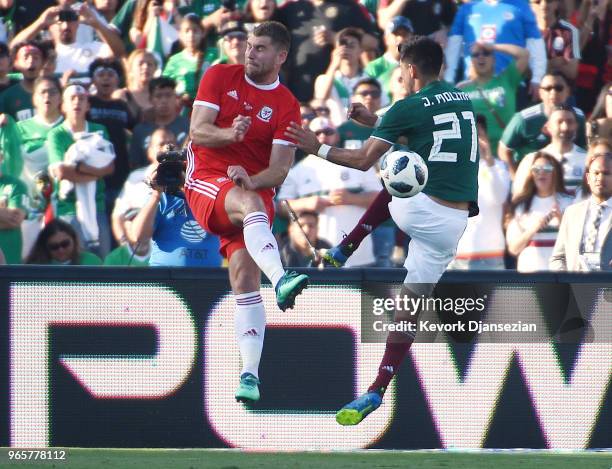 Sam Vokes of Wales in kicks the ball away from Jesus Molina#21 of Mexico during the first half of their friendly international soccer match at the...