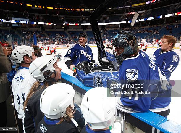 Goaltender Mike Smith of the Tampa Bay Lightning talks with fans as he stretches for pre-game skate against the Calgary Flames at the St. Pete Times...