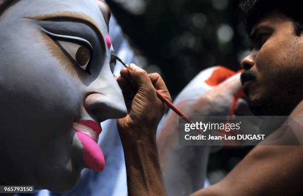 Communauté des sculpteurs de dieux, dans le quartier de Kumartuli. Maquillage à la peinture du visage de la déesse Kali. Communauté des sculpteurs de...