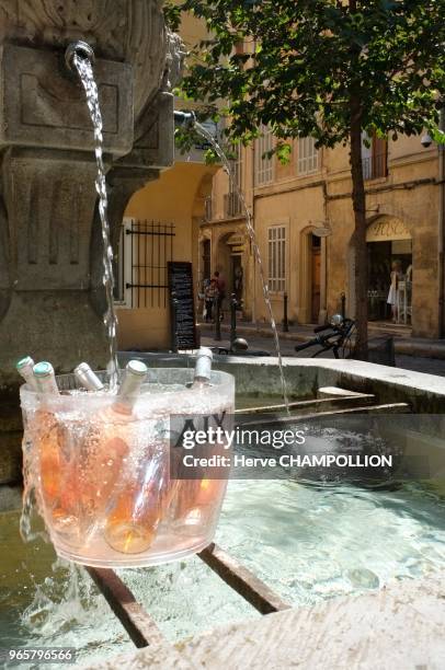 Bouteilles de vin rosé dans un sceau à rafraichir dans une fontaine de la vieille ville, Aix-en-Provence .