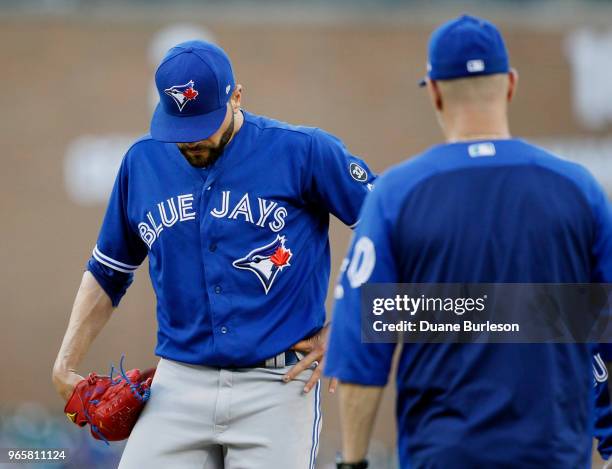 Pitcher Jaime Garcia of the Toronto Blue Jays is visited by pitching coach Pete Walker of the Toronto Blue Jays after giving up four hits to the...