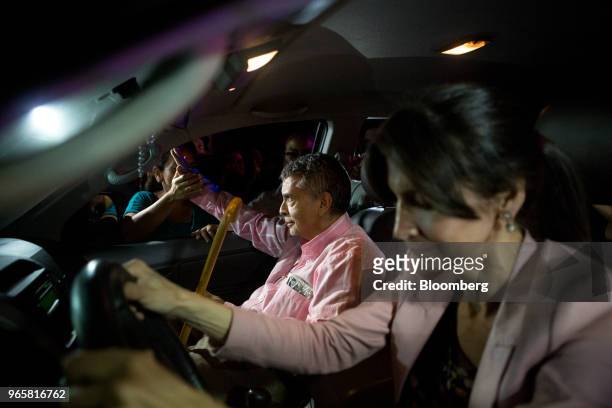 Retired general Angel Vivas, left, waves as he sits in a vehicle with his wife outside the Bolivarian Intelligence Service prison in Caracas,...