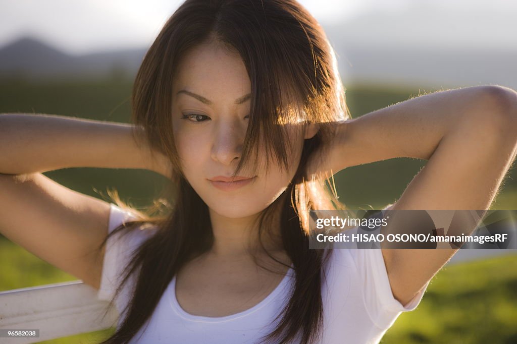 Young woman beside pasture, Tochigi prefecture, Japan