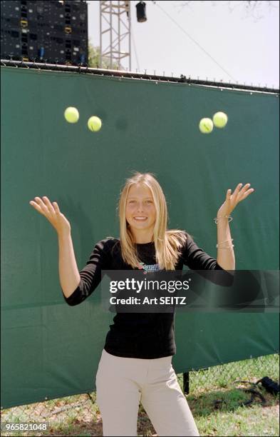 Junior russian tennis champion Maria Sharipova tosses four balls.