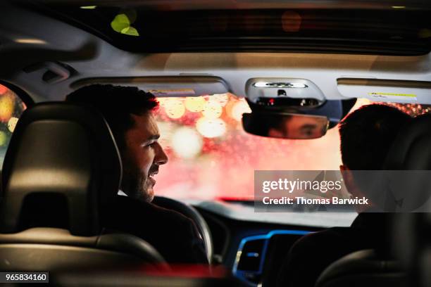 two businessmen in discussion in car while waiting in rush hour traffic - car passenger stock pictures, royalty-free photos & images