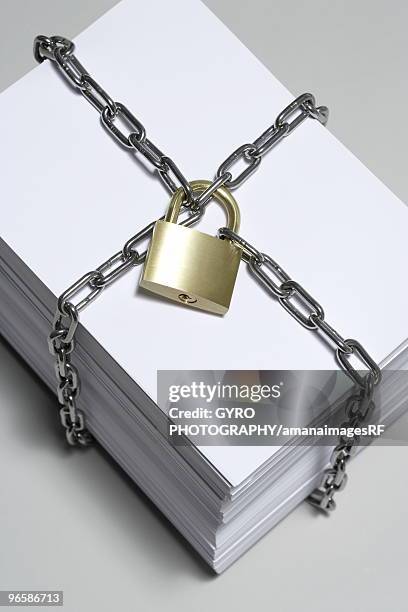 padlock and chain around a ream of paper - ream of paper stock pictures, royalty-free photos & images