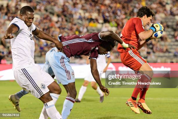 Brian Rowe of Vancouver Whitecaps collects a save past Dominique Badji of Colorado Rapids at Dick's Sporting Goods Park on June 1, 2018 in Commerce...