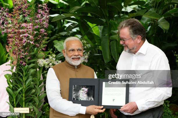 Group Director of Singapore Botanic Gardens, Dr Nigel Taylor and Indian Prime Minister Narendra Modi, pose for a photo with the orchid 'Dendrobium...