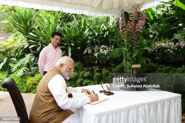 Indian Prime Minister Narendra Modi signs the guest book as Singapore Minister for Education and Second Minster for Ministry of Defence, Ong Ye Kung...