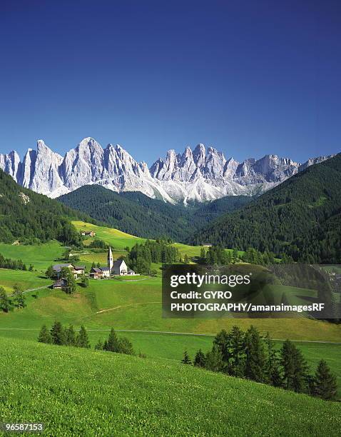 small village and farmland in front of geisler gruppe, italy - gruppe stock pictures, royalty-free photos & images